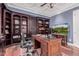 Comfortable home office featuring custom shelving and a modern ceiling fan at 2458 E Melrose St, Mesa, AZ 85213