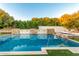 A luxurious pool featuring stone accents and multiple waterfalls, surrounded by lush landscaping, creates a serene backyard oasis at 2458 E Melrose St, Mesa, AZ 85213