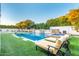 A luxurious pool features stone accents and a spa, surrounded by lush landscaping, creating a serene backyard oasis at 2458 E Melrose St, Mesa, AZ 85213