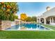 A luxurious pool featuring stone accents and multiple waterfalls, surrounded by lush landscaping, creates a serene backyard oasis at 2458 E Melrose St, Mesa, AZ 85213