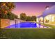 A luxurious pool features stone accents and multiple waterfalls, complementing the home's architecture and creating a backyard oasis at 2458 E Melrose St, Mesa, AZ 85213