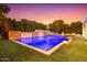 A luxurious pool featuring stone accents and multiple waterfalls, surrounded by lush landscaping, creates a serene backyard oasis at 2458 E Melrose St, Mesa, AZ 85213