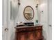 Stylish powder room boasting a wooden vanity, a round mirror, and sconce lighting at 2458 E Melrose St, Mesa, AZ 85213