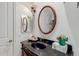 Elegant powder room with a decorative vanity, granite countertop, and ornate wall sconces at 2458 E Melrose St, Mesa, AZ 85213