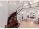 Elegant curved staircase with dark wood treads and white risers, leading to an open second-floor landing at 2458 E Melrose St, Mesa, AZ 85213