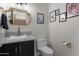 Stylish powder room with a vessel sink, dark cabinets, and decorative gold mirror and accents at 2500 Lupine Ln, Wickenburg, AZ 85390