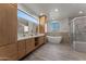 This bathroom has a walk-in shower, a free standing tub, double vanity, and natural wood cabinets at 2500 Lupine Ln, Wickenburg, AZ 85390