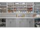 Well-organized pantry with white cabinetry, ample shelving, and countertop space for storage and food preparation at 2500 Lupine Ln, Wickenburg, AZ 85390