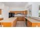 Well-lit kitchen with oak cabinets, a center island, and modern black appliances at 27467 N 75Th Way, Scottsdale, AZ 85266
