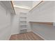 Bright walk-in closet with wooden hanging rods and built-in shelves at 27467 N 75Th Way, Scottsdale, AZ 85266