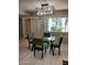 Cozy dining area with a glass table, four green chairs, and bright natural light at 276 Leisure World --, Mesa, AZ 85206