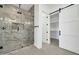 Luxurious bathroom featuring a marble tile shower with sleek glass door and a sliding barn door to the walk-in closet at 39323 W Flower St, Tonopah, AZ 85354