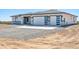 Single-story home with desert landscaping, three car garage and a white and gray color scheme at 39323 W Flower St, Tonopah, AZ 85354