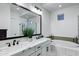 Bright bathroom with double sinks, marble countertop, modern fixtures, and a luxurious soaking tub at 3947 E Austin Dr, Gilbert, AZ 85296