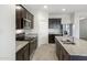 Modern kitchen with granite countertops, dark cabinets, and stainless steel appliances at 42890 W Peters Dr, Maricopa, AZ 85138