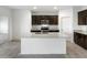 Spacious kitchen featuring dark wood cabinetry and a large center island with a granite countertop at 42890 W Peters Dr, Maricopa, AZ 85138