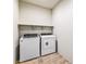 Laundry room with washer, dryer, and shelving offers convenience and organization at 42890 W Peters Dr, Maricopa, AZ 85138