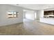 Open-concept living area features neutral tones and seamless flow into the kitchen area at 42890 W Peters Dr, Maricopa, AZ 85138