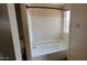 Cozy bathroom featuring white tiled shower-tub and a window for natural light at 433 E Utopia Rd, Phoenix, AZ 85024