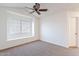 A bedroom with neutral carpet, window, and a ceiling fan at 433 E Utopia Rd, Phoenix, AZ 85024
