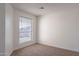 A simple and clean bedroom with carpeted floors and a bright window at 433 E Utopia Rd, Phoenix, AZ 85024