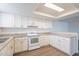 Bright kitchen features white cabinets, stone countertops, and modern appliances under a skylight at 433 E Utopia Rd, Phoenix, AZ 85024