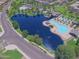 Aerial view of the community pool, lake, and landscaping on a sunny day at 44196 W Askew Dr, Maricopa, AZ 85138