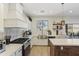 Well-lit kitchen with white cabinets, a stainless steel sink, and a view of the backyard at 44196 W Askew Dr, Maricopa, AZ 85138