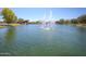 Scenic community pond featuring water fountains and lakeside clubhouse at 44196 W Askew Dr, Maricopa, AZ 85138