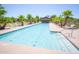 Inviting community pool with palm trees, lounge chairs and a covered patio area at 44196 W Askew Dr, Maricopa, AZ 85138
