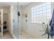 White tiled walk-in shower with glass door and glass block window at 44196 W Askew Dr, Maricopa, AZ 85138