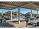 View of a pool area in a community, featuring tables, chairs, lounge chairs, and community buildings at 4424 S 127Th Ave, Avondale, AZ 85323