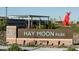 Hay Moon Park sign, featuring shade structure, landscaping, and a unique red art installation at 4424 S 127Th Ave, Avondale, AZ 85323