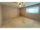 Neutral-toned bedroom with vinyl flooring, ceiling fan, and a bright window at 5828 E Dallas St, Mesa, AZ 85205