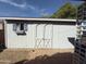 Exterior view of a white backyard shed with double doors, a window, and a flower box below at 5828 E Dallas St, Mesa, AZ 85205