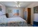 Cozy bedroom featuring a plush bed, wooden wardrobe, ceiling fan, and bright window at 7103 N 28Th Dr, Phoenix, AZ 85051