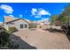 The backyard features desert landscaping, gravel, block wall, shrubs, small trees and a home's exterior at 7515 W Jenan Dr, Peoria, AZ 85345