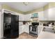 Efficient kitchen with white cabinets, stainless steel appliances, and essential cookware at 7977 W Wacker Rd # 171, Peoria, AZ 85381