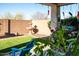 Charming backyard with lush greenery, artificial grass, and covered patio area at 808 E Constance Way, Phoenix, AZ 85042