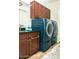 A well-equipped laundry room with modern washer and dryer units and ample cabinet space at 808 E Constance Way, Phoenix, AZ 85042