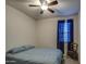 Simple bedroom featuring blue bedding, fan, window, and a decorative chair at 8420 S 69Th Ln, Laveen, AZ 85339