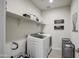 Bright laundry room featuring a modern washer and dryer, shelving, and stylish decor at 8420 S 69Th Ln, Laveen, AZ 85339