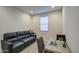 Modern office space features a comfortable black leather couch, desk, chair, and natural light at 8420 S 69Th Ln, Laveen, AZ 85339