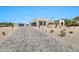 Beautiful home with a long driveway, desert landscaping, and a private gate, set against a clear blue sky at 8730 E Tether Trl, Scottsdale, AZ 85255