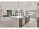 Open-concept kitchen and living space with a large center island, sleek lighting, and modern finishes at 8730 E Tether Trl, Scottsdale, AZ 85255