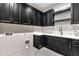 Modern kitchenette with dark cabinetry, open shelving, white counters and patterned backsplash at 8730 E Tether Trl, Scottsdale, AZ 85255
