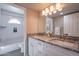 Bright bathroom featuring a double vanity with granite countertops and a separate tub and shower area at 10490 E Dreyfus E Ave, Scottsdale, AZ 85260