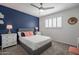 Chic bedroom featuring a dark accent wall, plush bedding, and shuttered windows for natural light at 10490 E Dreyfus E Ave, Scottsdale, AZ 85260