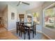 Bright dining area with large windows, wood floors, a ceiling fan, and backyard views at 10490 E Dreyfus E Ave, Scottsdale, AZ 85260