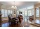 Elegant dining room featuring wood floors, chandelier, and bright, sunlit windows with open access to the living room at 10490 E Dreyfus E Ave, Scottsdale, AZ 85260